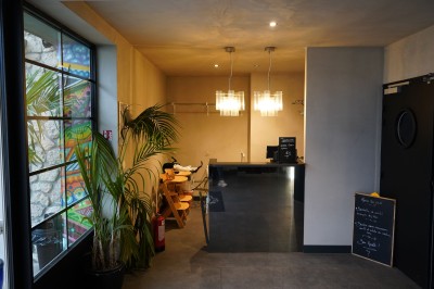 Toilettes roses décorées de mosaïques, affiches rétro sur les murs et miroir éclairé par des ampoules.