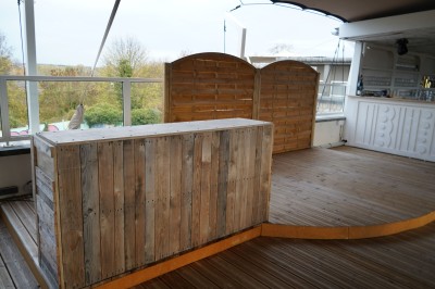 Toilettes roses décorées de mosaïques, affiches rétro sur les murs et miroir éclairé par des ampoules.