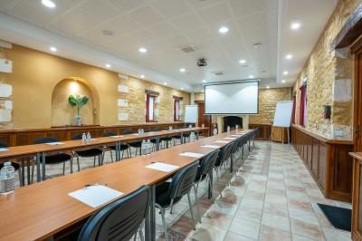 Table en bois dressée avec des verres, des couverts et des serviettes blanches, en extérieur avec un fond de verdure.