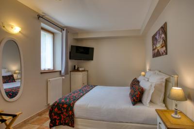 Table en bois dressée avec des verres, des couverts et des serviettes blanches, en extérieur avec un fond de verdure.