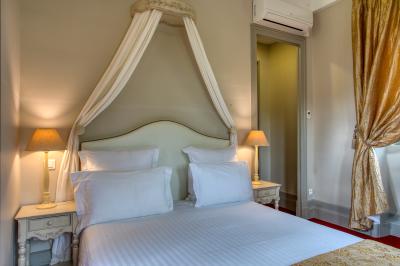 Table en bois dressée avec des verres, des couverts et des serviettes blanches, en extérieur avec un fond de verdure.