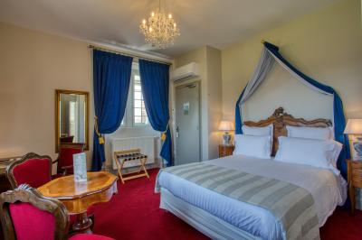 Table en bois dressée avec des verres, des couverts et des serviettes blanches, en extérieur avec un fond de verdure.
