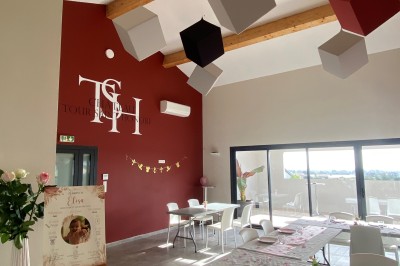 Miniature Location salle La Londe-les-Maures (Var) - Château Tour Saint Honoré #2 Un homme tenant un seau transparent rempli de bouteilles de vin rosé, en extérieur avec un fond flou de verdure.