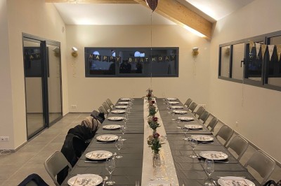 Miniature Location salle La Londe-les-Maures (Var) - Château Tour Saint Honoré #6 Un homme tenant un seau transparent rempli de bouteilles de vin rosé, en extérieur avec un fond flou de verdure.