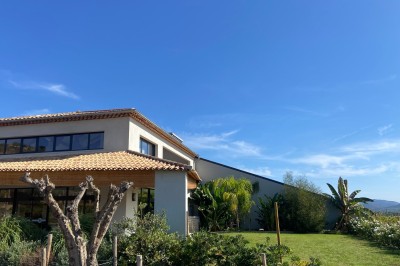 Miniature Location salle La Londe-les-Maures (Var) - Château Tour Saint Honoré #9 Un homme tenant un seau transparent rempli de bouteilles de vin rosé, en extérieur avec un fond flou de verdure.