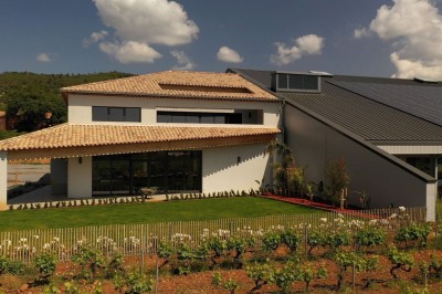 Miniature Location salle La Londe-les-Maures (Var) - Château Tour Saint Honoré #3 Un homme tenant un seau transparent rempli de bouteilles de vin rosé, en extérieur avec un fond flou de verdure.