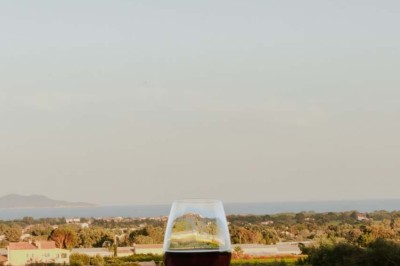 Miniature Location salle La Londe-les-Maures (Var) - Château Tour Saint Honoré #12 Un homme tenant un seau transparent rempli de bouteilles de vin rosé, en extérieur avec un fond flou de verdure.