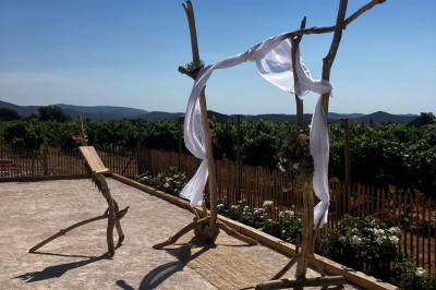 Miniature Location salle La Londe-les-Maures (Var) - Château Tour Saint Honoré #27 Structure en bois décorée de voiles blancs, installée en extérieur devant des vignes sous un ciel dégagé.