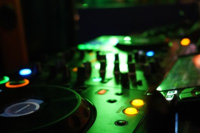 Bar moderne avec éclairage bleu, étagères remplies de bouteilles et ambiance tamisée.