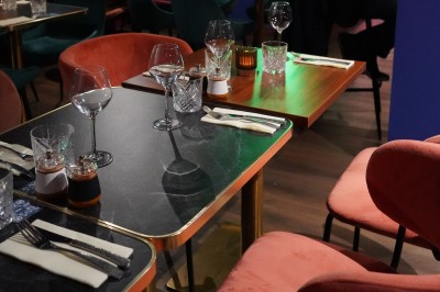 Bar moderne avec éclairage bleu, étagères remplies de bouteilles et ambiance tamisée.