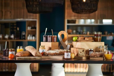 Plateaux de desserts comprenant verrines, madeleines et autres douceurs, disposés près d'une machine à café.