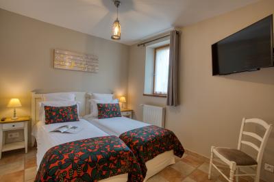 Façade d'un château en pierre entouré de végétation, avec un ciel bleu partiellement nuageux en arrière-plan.