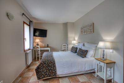 Façade d'un château en pierre entouré de végétation, avec un ciel bleu partiellement nuageux en arrière-plan.