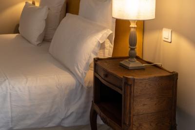 Façade d'un château en pierre entouré de végétation, avec un ciel bleu partiellement nuageux en arrière-plan.