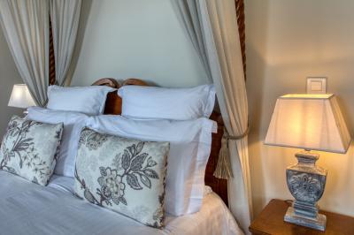 Façade d'un château en pierre entouré de végétation, avec un ciel bleu partiellement nuageux en arrière-plan.