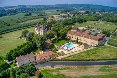 Bain à remous en fonctionnement avec eau bouillonnante, entouré d'un mur en pierre et d'un mur rouge.