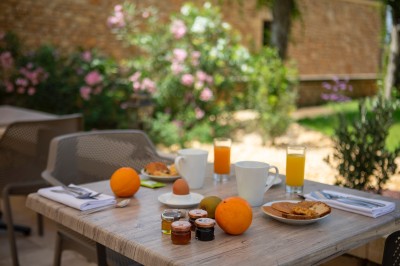Bain à remous en fonctionnement avec eau bouillonnante, entouré d'un mur en pierre et d'un mur rouge.
