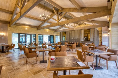 Bain à remous en fonctionnement avec eau bouillonnante, entouré d'un mur en pierre et d'un mur rouge.