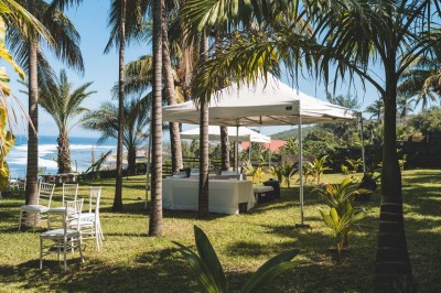 Allée extérieure éclairée la nuit, bordée de végétation et d'un bâtiment blanc avec des marquages au sol.