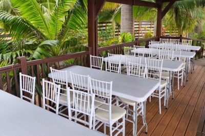 Allée extérieure éclairée la nuit, bordée de végétation et d'un bâtiment blanc avec des marquages au sol.