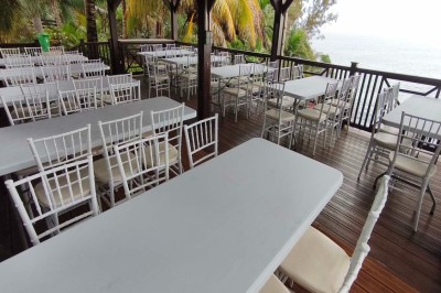 Allée extérieure éclairée la nuit, bordée de végétation et d'un bâtiment blanc avec des marquages au sol.