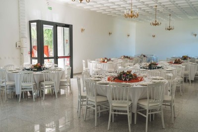 Allée extérieure éclairée la nuit, bordée de végétation et d'un bâtiment blanc avec des marquages au sol.