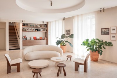 Miniature Location salle Cassis (Bouches-du-Rhône) - Hôtel Liautaud Cassis #12 Salon lumineux avec canapé beige incurvé, chaises en bois, tables basses rondes et plantes en pot près de grandes fenêtres.