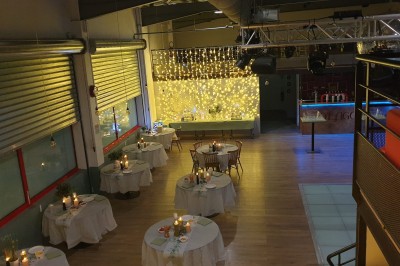 Couloir avec sol en bois, trois portes colorées (rose, bleu, jaune) et un lavabo avec miroir au fond.