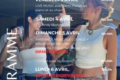 Terrasse d'un restaurant avec voiles d'ombrage, mobilier en bois, vue sur un étang et ambiance estivale.