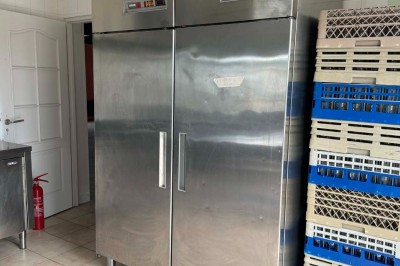 Miniature Location salle Saint-Barthélemy-d'Anjou (Maine-et-Loire) - Blue Event #16 Deux grandes armoires réfrigérées en acier inoxydable dans une pièce carrelée avec des caisses empilées à droite.