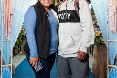 Un groupe de personnes pose devant la tour Eiffel par temps nuageux, dans un espace dégagé bordé d'arbres.