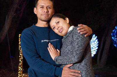 Un groupe de personnes pose devant la tour Eiffel par temps nuageux, dans un espace dégagé bordé d'arbres.