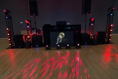 Installation de matériel de sonorisation et d'éclairage avec projecteurs rouges sur une scène en intérieur.