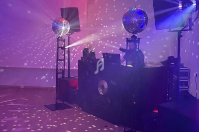 Installation de matériel de sonorisation et d'éclairage avec boules à facettes projetant des lumières colorées.