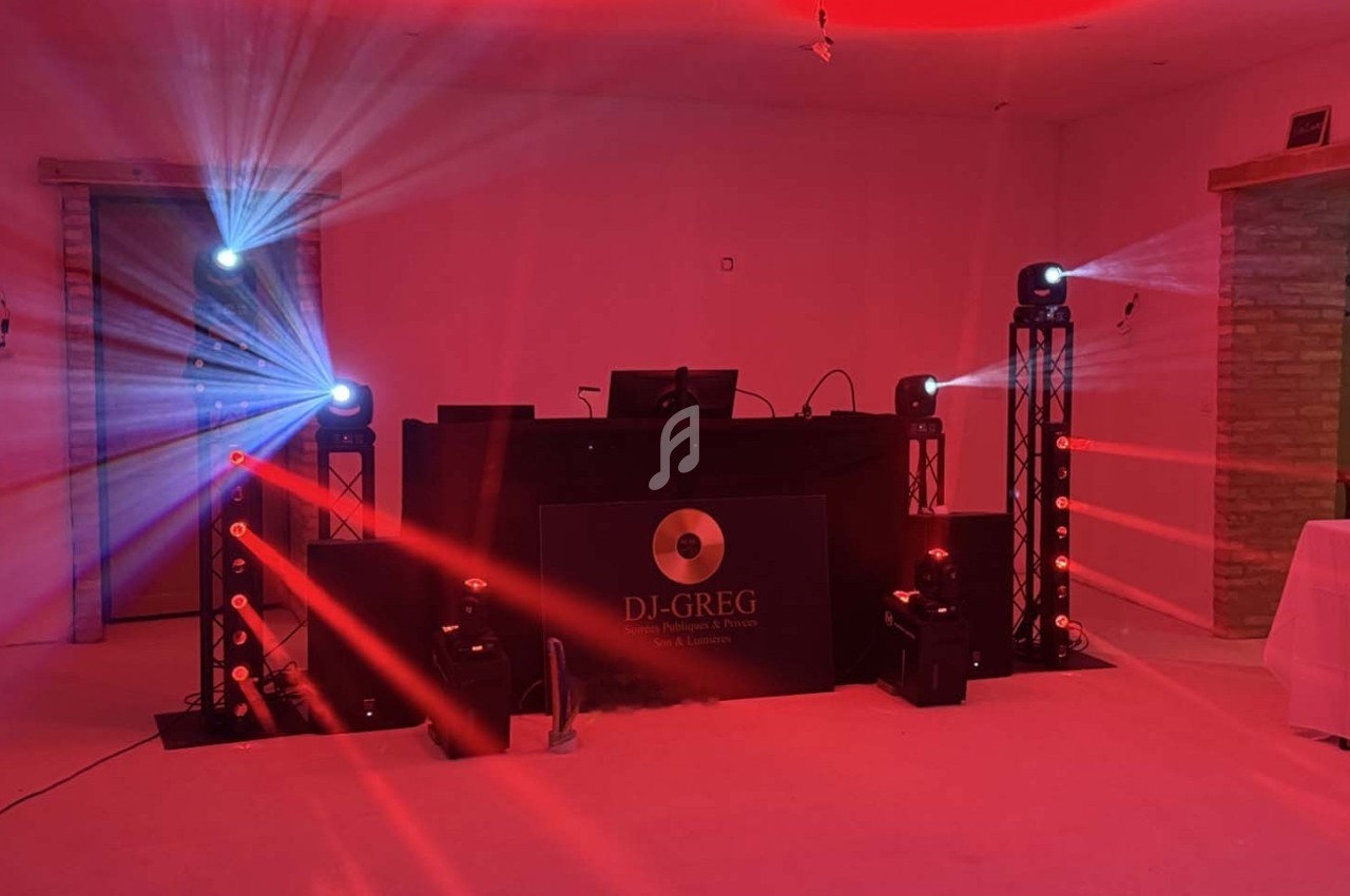 Installation de matériel de sonorisation et éclairage avec projecteurs rouges et bleus dans une salle.