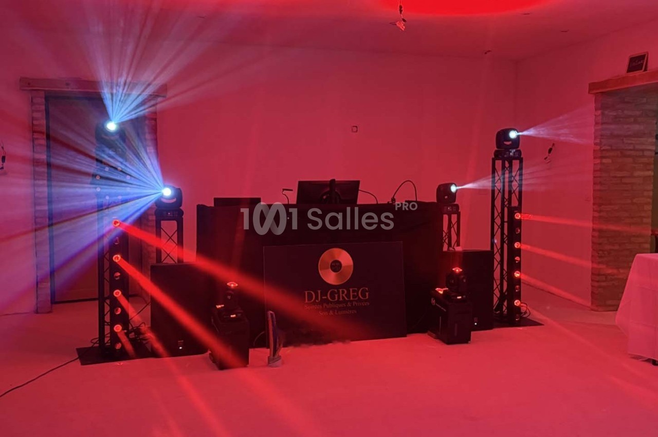 Installation de matériel de sonorisation et éclairage avec projecteurs rouges et bleus dans une salle.