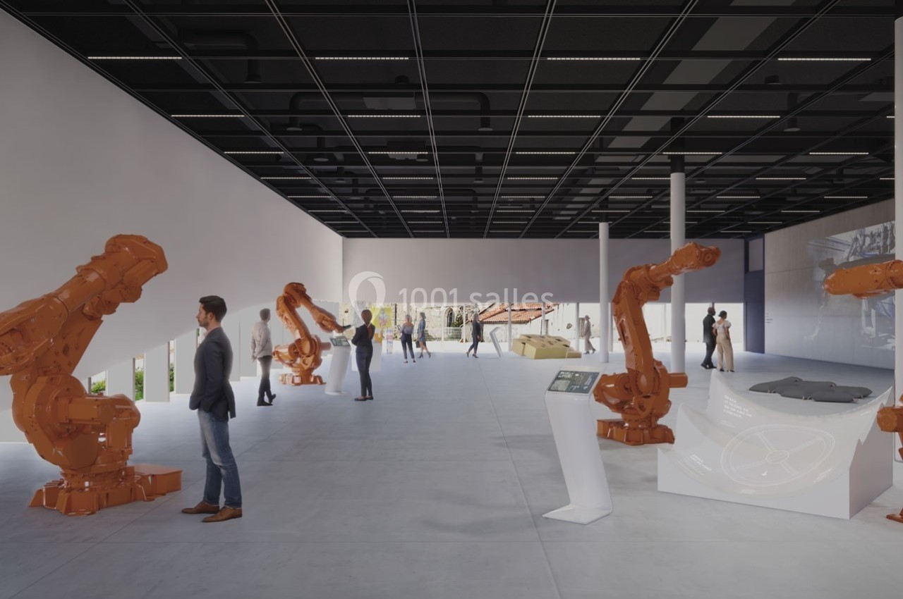 Salle moderne avec des robots industriels orange en démonstration, des visiteurs observant et interagissant avec des écrans…