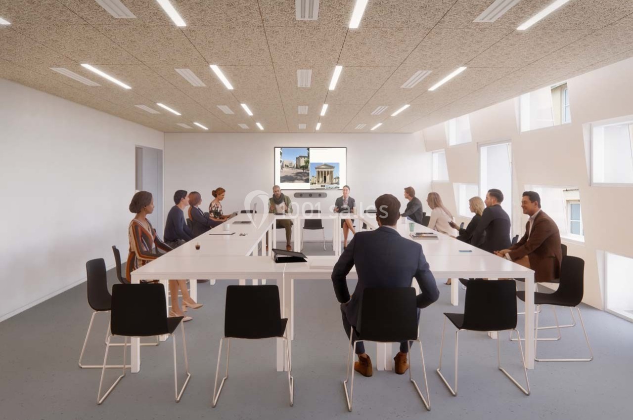 Personnes assises autour de tables blanches en configuration de réunion dans une salle lumineuse et moderne.