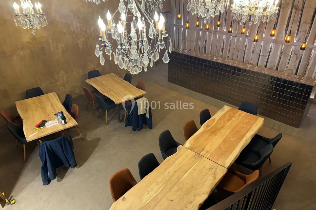 Salle à manger élégante avec grandes tables en bois, chaises colorées et lustres en cristal suspendus.