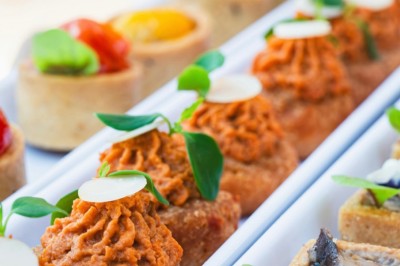 Desserts variés présentés dans des verrines, incluant des mousses, fruits frais et pâtisseries en arrière-plan.