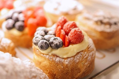 Desserts variés présentés dans des verrines, incluant des mousses, fruits frais et pâtisseries en arrière-plan.