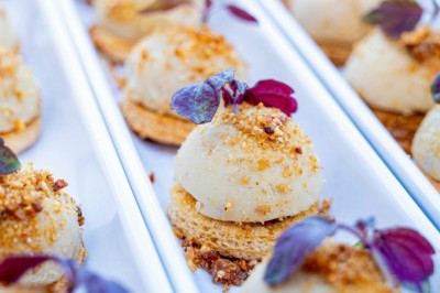 Desserts variés présentés dans des verrines, incluant des mousses, fruits frais et pâtisseries en arrière-plan.