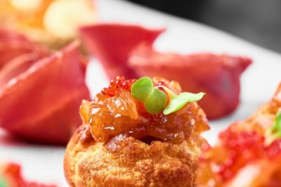 Desserts variés présentés dans des verrines, incluant des mousses, fruits frais et pâtisseries en arrière-plan.