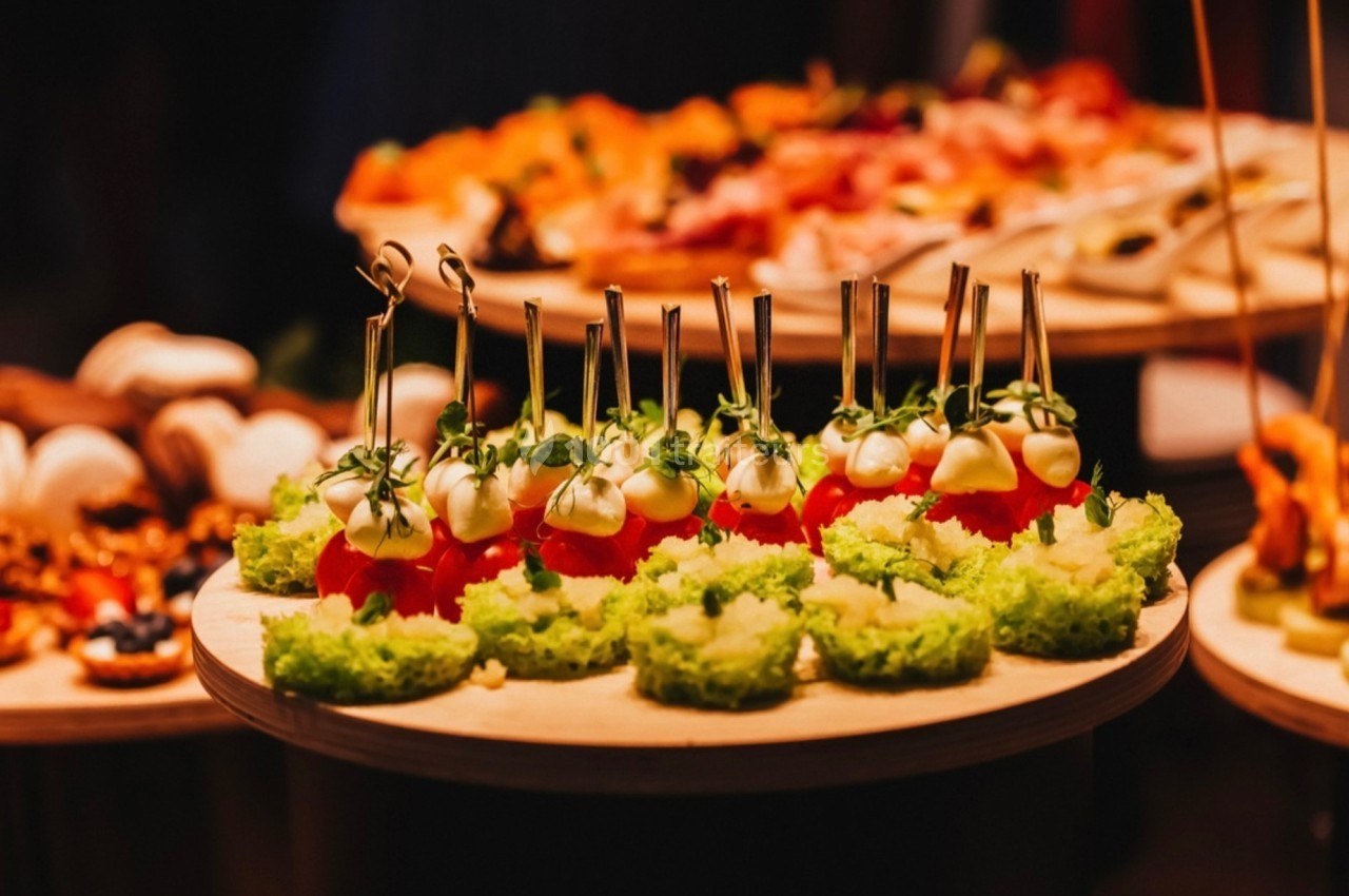 Plateau de bouchées apéritives avec tomates cerises, fromage, herbes fraîches et bases vertes sur des piques.