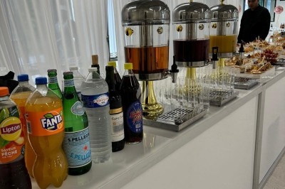 Assiette de burrata garnie de tomates cerises colorées et décorée d'une fleur violette sur une table blanche.