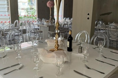 Assiette de burrata garnie de tomates cerises colorées et décorée d'une fleur violette sur une table blanche.