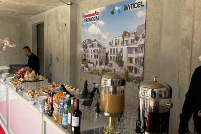 Assiette de burrata garnie de tomates cerises colorées et décorée d'une fleur violette sur une table blanche.
