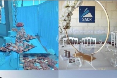 Assiette de burrata garnie de tomates cerises colorées et décorée d'une fleur violette sur une table blanche.