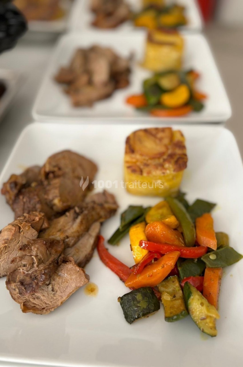 Assiette contenant de la viande rôtie, des légumes grillés colorés et un gratin de pommes de terre.
