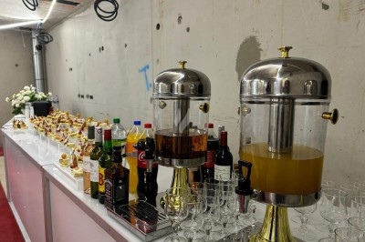 Assiette de burrata garnie de tomates cerises colorées et décorée d'une fleur violette sur une table blanche.